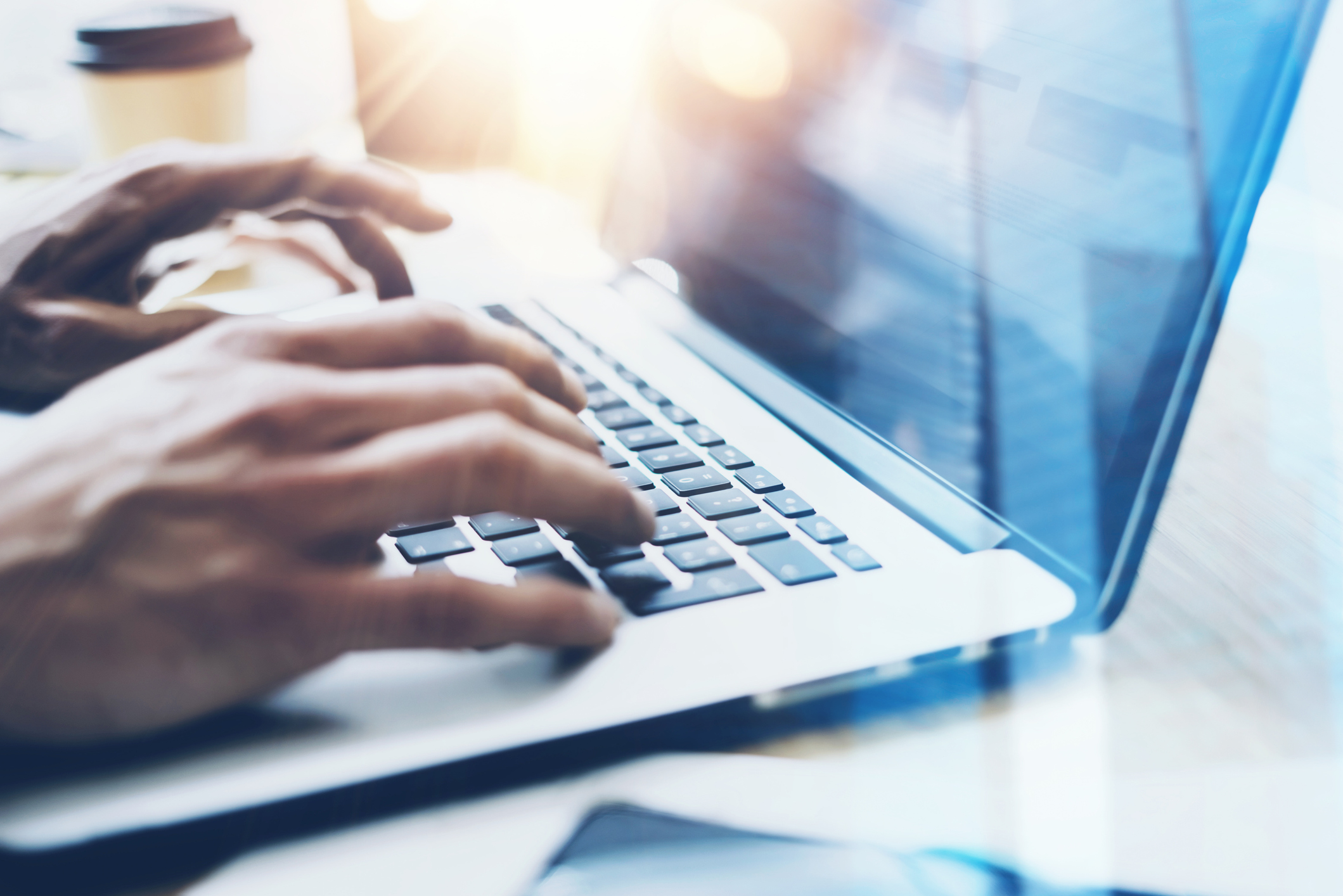 Mains tapant sur un clavier d'ordinateur, représentant le développement d'applications sur mesure.